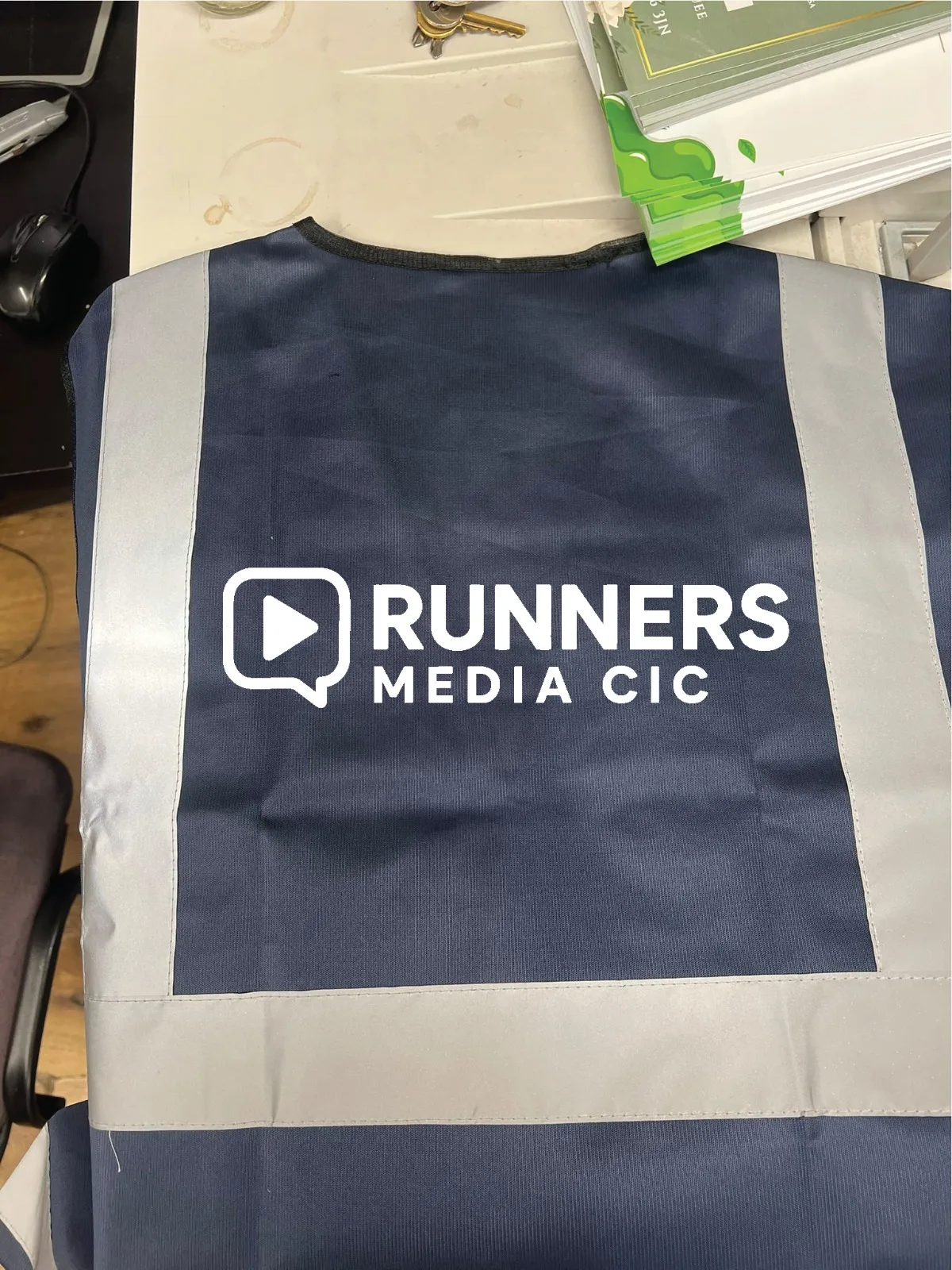 Back of navy hi-vis vest with large custom logo print across the shoulders