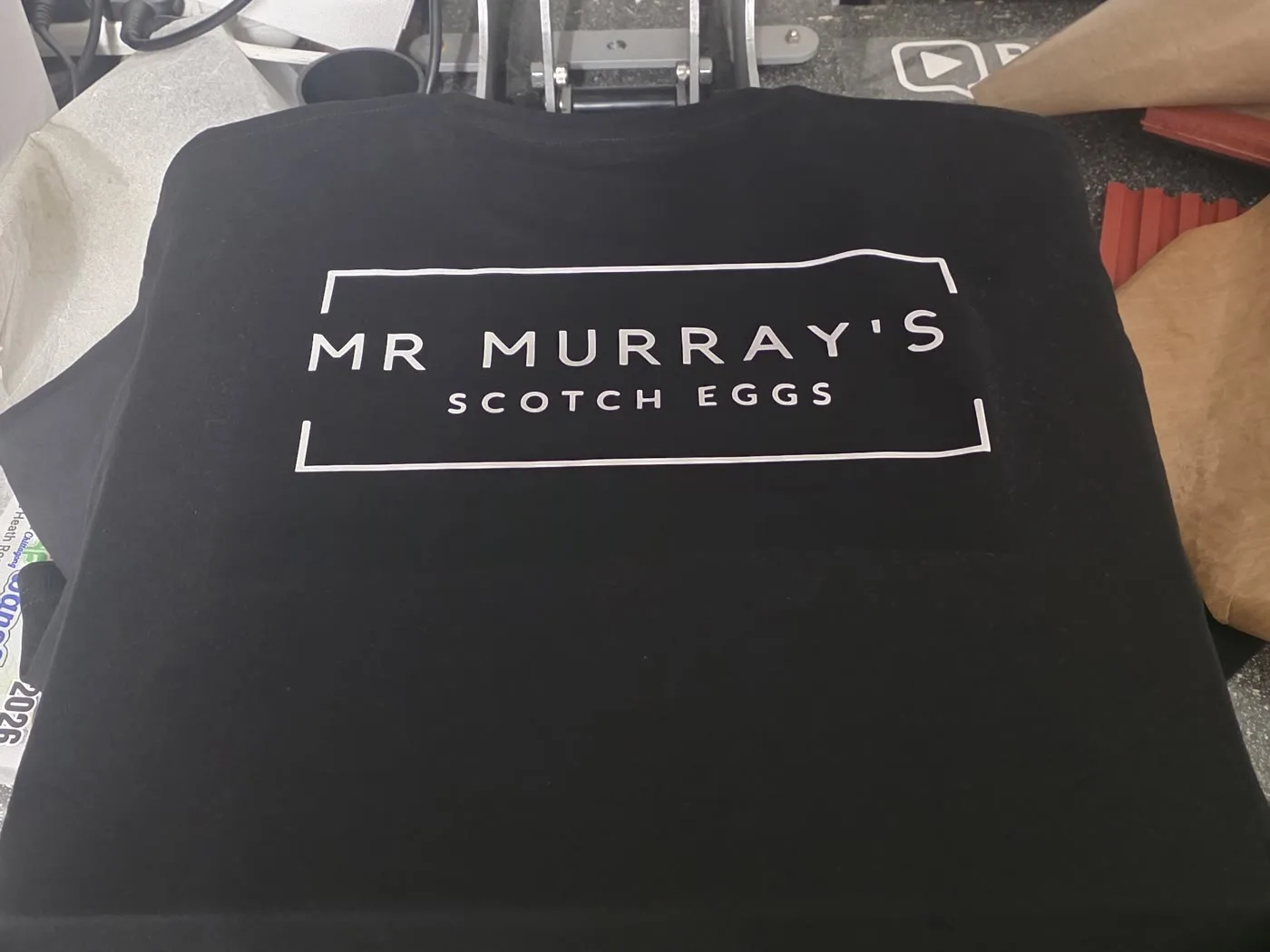 Mr Murray's Scotch Eggs branded workwear t-shirt on the heat press at our London workshop